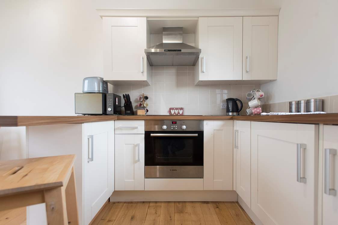 The kitchen is complete with an induction hob, and is compact, light and airy.