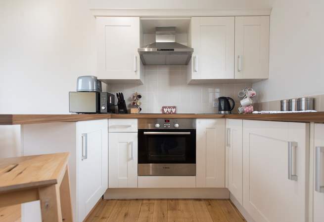 The kitchen is complete with an induction hob, and is compact, light and airy.