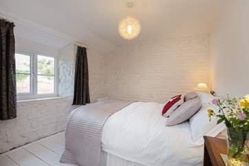 This is the first of the double bedrooms, with lovely painted floorboards and views out to the front of the cottage and the fields.