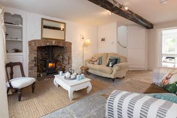 There are two beautiful sitting-rooms. Each has a wood-burning stove and original flagstone floor. This one leads on through to the kitchen/dining-room.
