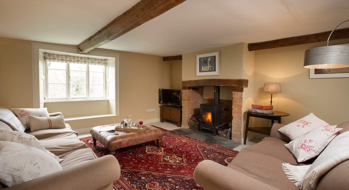 This is the sitting-room with a wood-burning stove, deep comfortable sofas and a lovely warm atmosphere.