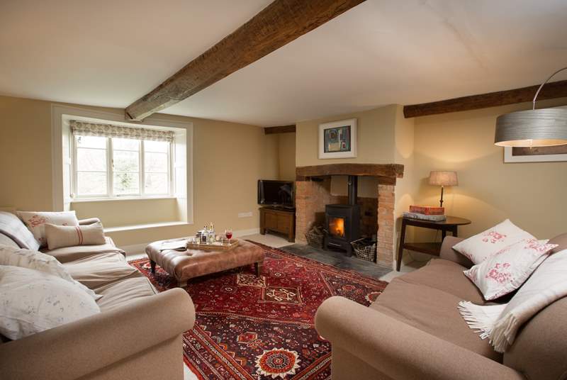 This is the sitting-room with a wood-burning stove, deep comfortable sofas and a lovely warm atmosphere.