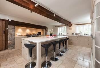 The farmhouse has a stunning contemporary kitchen with a range cooker, a huge sociable island and gorgeous stone flooring.