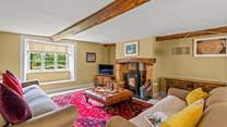 This is the sitting-room with a wood-burning stove, deep comfortable sofas and a lovely warm atmosphere.