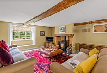This is the sitting-room with a wood-burning stove, deep comfortable sofas and a lovely warm atmosphere.