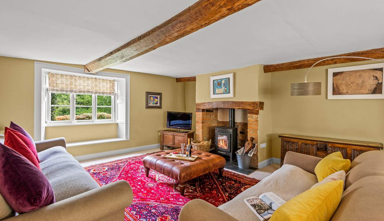 This is the sitting-room with a wood-burning stove, deep comfortable sofas and a lovely warm atmosphere.