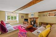 This is the sitting-room with a wood-burning stove, deep comfortable sofas and a lovely warm atmosphere.