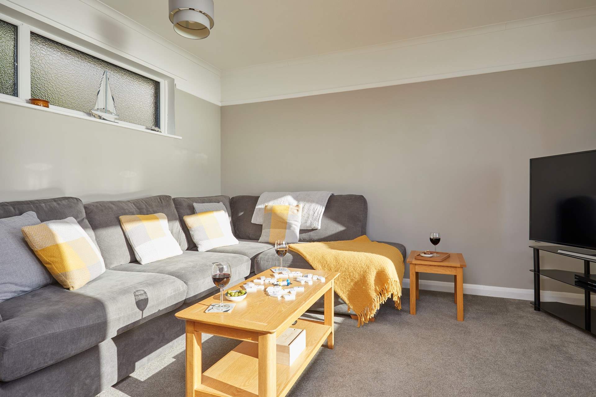 The comfy sofa in the TV room also has access to the patio and steps down to the garden.