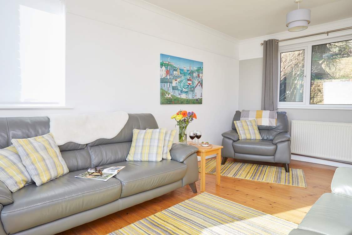 The relaxing sitting-room is bright and airy with windows to the front and patio doors with sea views.