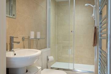 The fully tiled shower-room has a large cubicle.