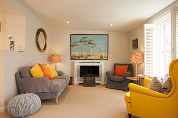 A cosy yet spacious sitting-room with vibrant colours bringing light and character to the room.