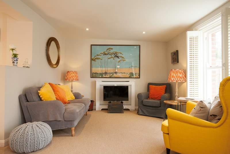 A cosy yet spacious sitting-room with vibrant colours bringing light and character to the room.