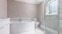 The en suite to Bedroom 5 has a large shower cubicle with drench head.