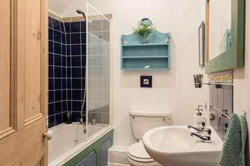 This bathroom has a bath with an overhead shower.