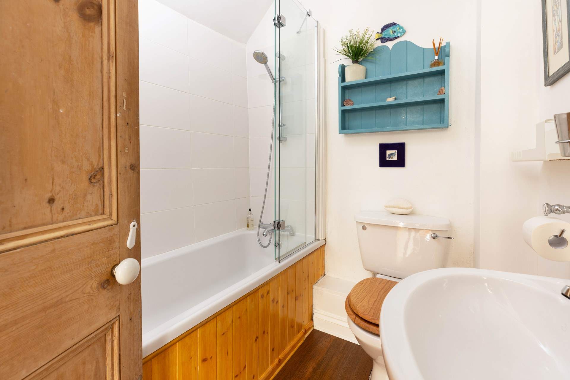 The family bathroom has a bath and over head shower. 