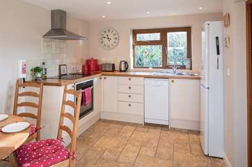 The modern kitchen has an induction hob, dishwasher and large fridge/freezer.