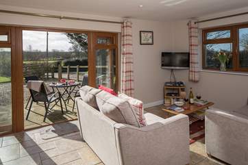 The sitting-area has French doors that open onto the patio and countryside beyond.