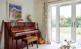 The sun-room with many musical instruments leads out to the stunning garden. - Thumbnail Image