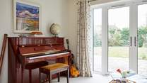 The sun-room with many musical instruments leads out to the stunning garden.