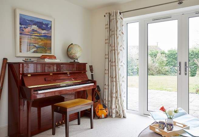 The sun-room with many musical instruments leads out to the stunning garden.