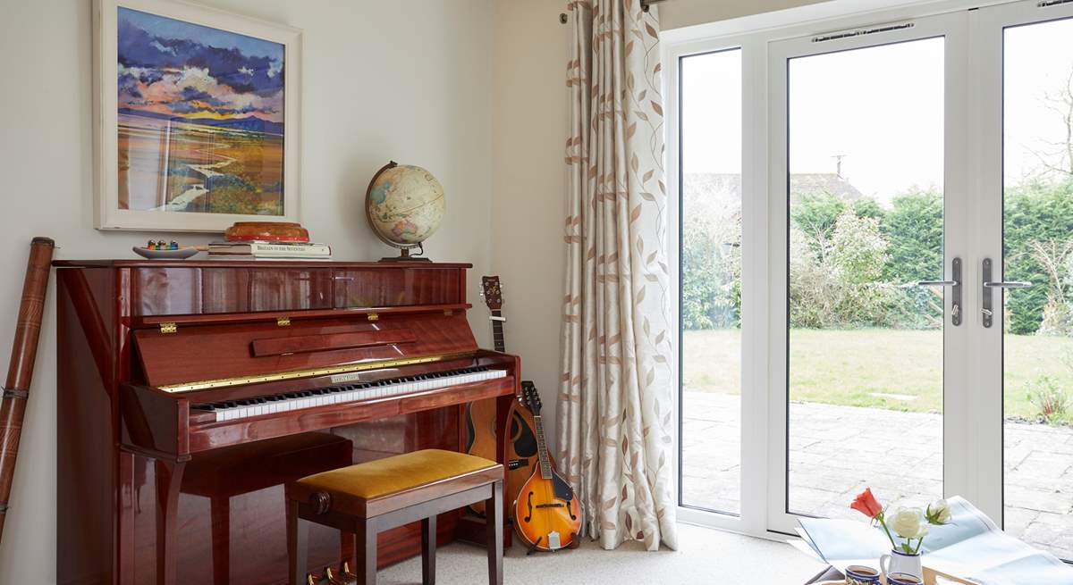 The sun-room with many musical instruments leads out to the stunning garden.