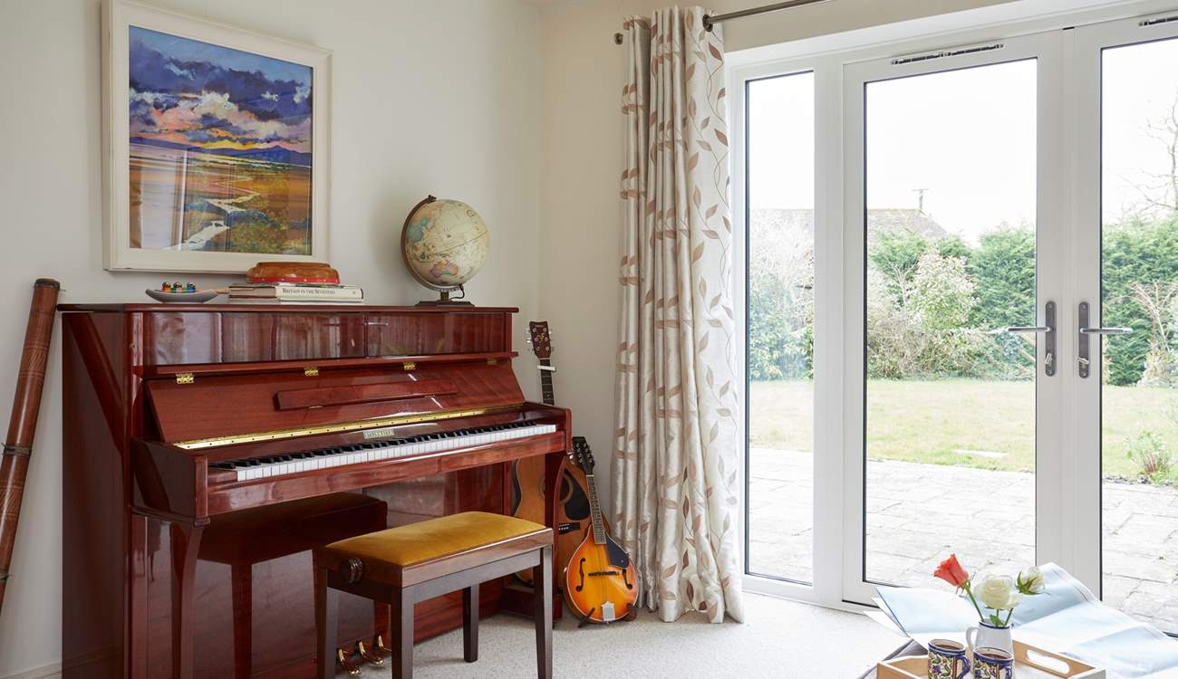 The sun-room with many musical instruments leads out to the stunning garden.