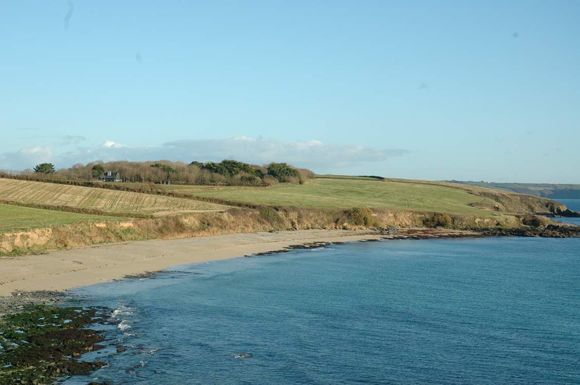 Looking at Towan Beach from Killigerran Headland with Rosteague Farmhouse nestling in the trees on the left.