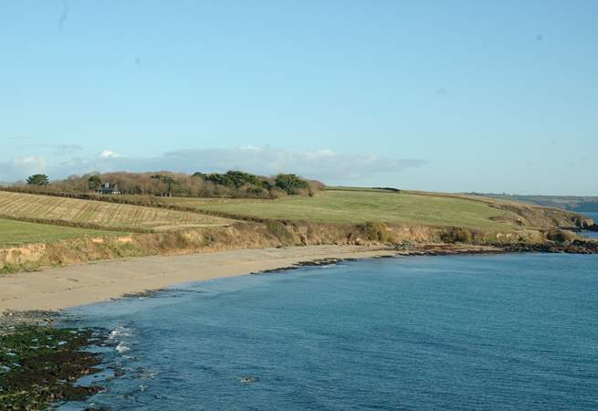 Looking at Towan Beach from Killigerran Headland with Rosteague Farmhouse nestling in the trees on the left.
