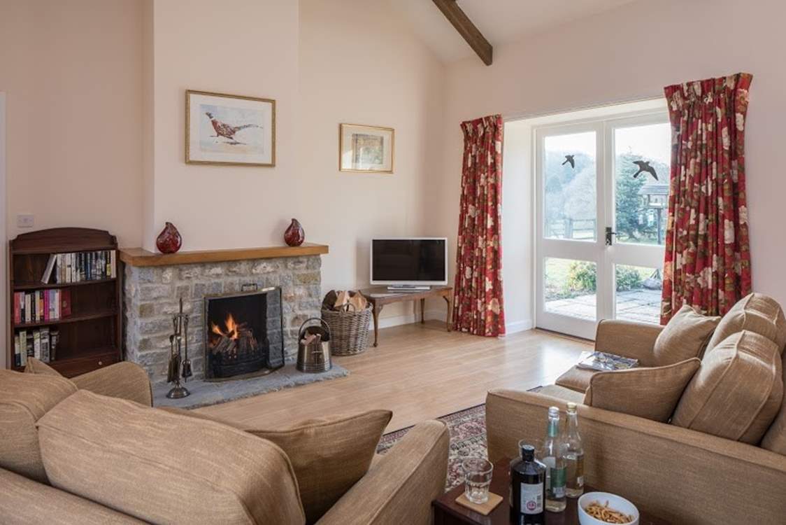 The sitting-room has a cosy open fire and French doors that lead out onto the beautiful garden.