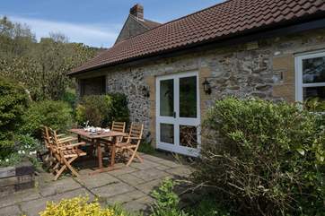 The south-facing patio is reached through the French doors from the sitting-room, perfect for al fresco dining.