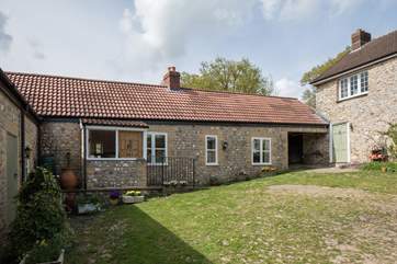 Stable Cottage faces onto the farm courtyard on this side, and the garden on the other. Parking is in front of the cottage and the owner's house to the right.