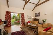 A large beamed sitting-room has French doors out onto the patio, and  the garden beyond.