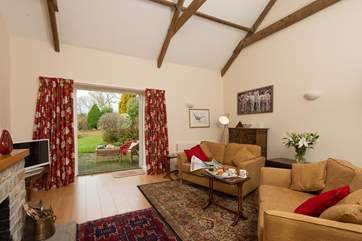 A large beamed sitting-room has French doors out onto the patio, and the garden beyond.