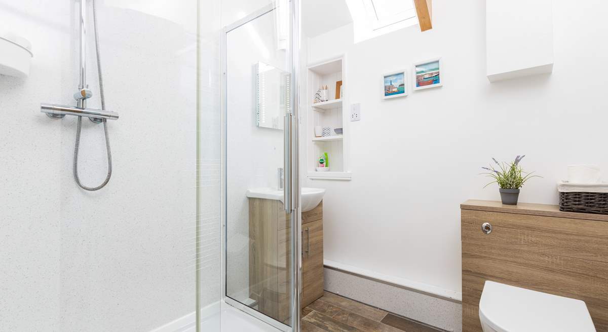 The en suite shower-room is next to the bedroom, three steps up from the living space.