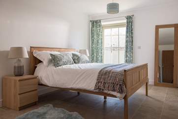The master bedroom is spacious and light and has a comfy king-size bed dressed with lovely linens.