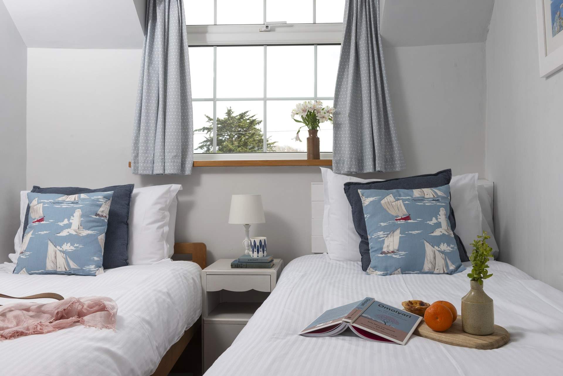 Crisp white linens and plump cushions dress the beds.