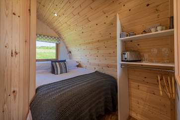 The double bed is tucked into the rear of the pod.