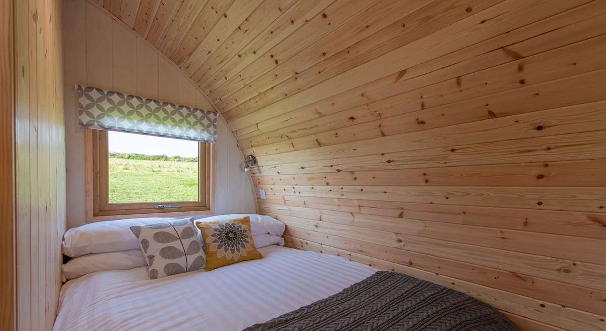 The cosy double bed is set at the rear of the pod with a window looking out to the meadow at the back.