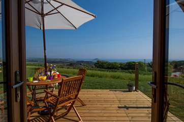 The decked and sheltered patio (enclosed by glazed panels on either side) with the most spectacular views towards The Mount and beyond.