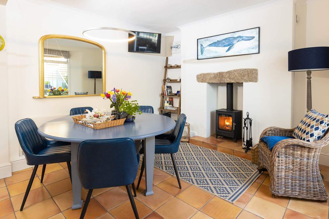 The dining-area has comfy chairs,  enjoy sitting around the table with the cosy wood-burner glowing.