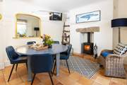 The dining-area has comfy chairs,  enjoy sitting around the table with the cosy wood-burner glowing.