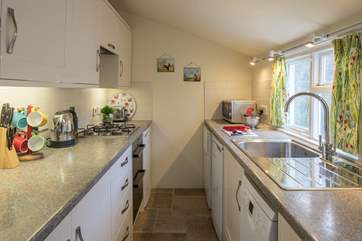 The well-equipped galley kitchen looks out over the courtyard garden.
