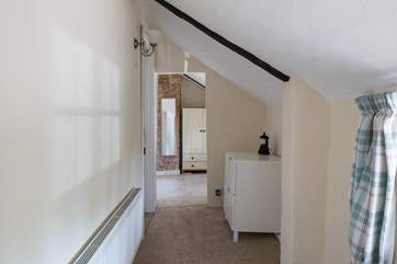 The first floor landing has a cloakroom to the left, storage space and pitched ceilings.