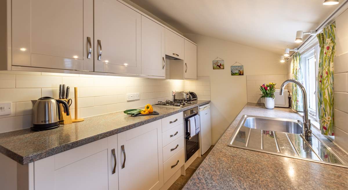 The well-equipped galley kitchen looks out over the pretty courtyard garden.