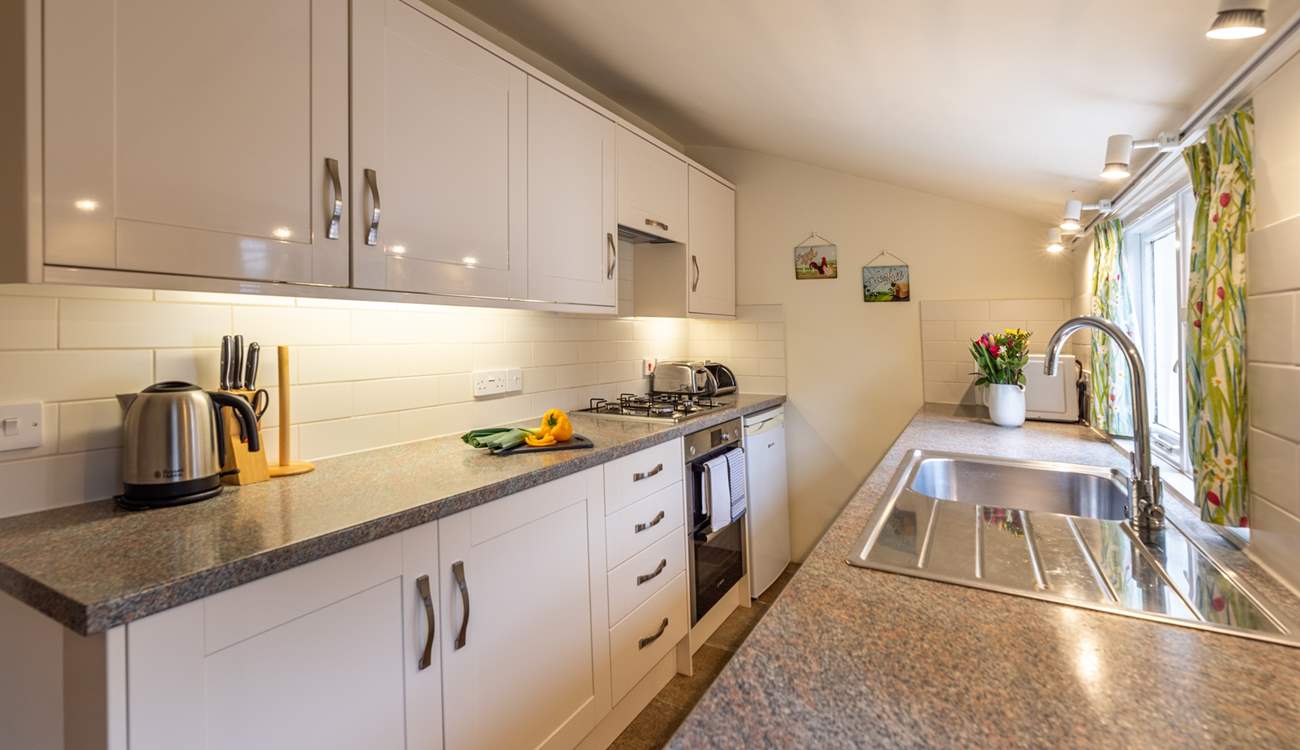 The well-equipped galley kitchen looks out over the pretty courtyard garden.