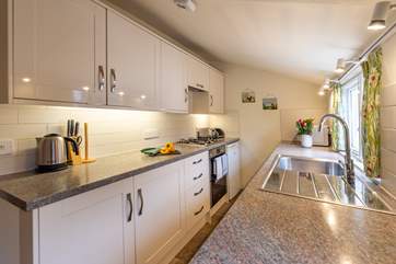 The well-equipped galley kitchen looks out over the pretty courtyard garden.