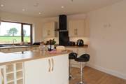 The kitchen looks out across fields at the back of the house and over the garden and lakes to the front.