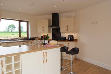 The kitchen looks out across fields at the back of the house and over the garden and lakes to the front.