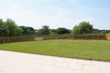 Another view of the garden. As well as the hot tub there is a barbecue, a picnic table and two sun loungers.