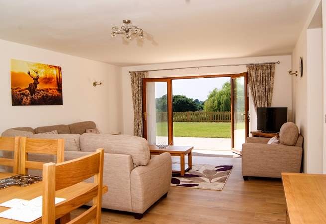 The living/dining room has French windows to the patio and garden and lovely country and lake views